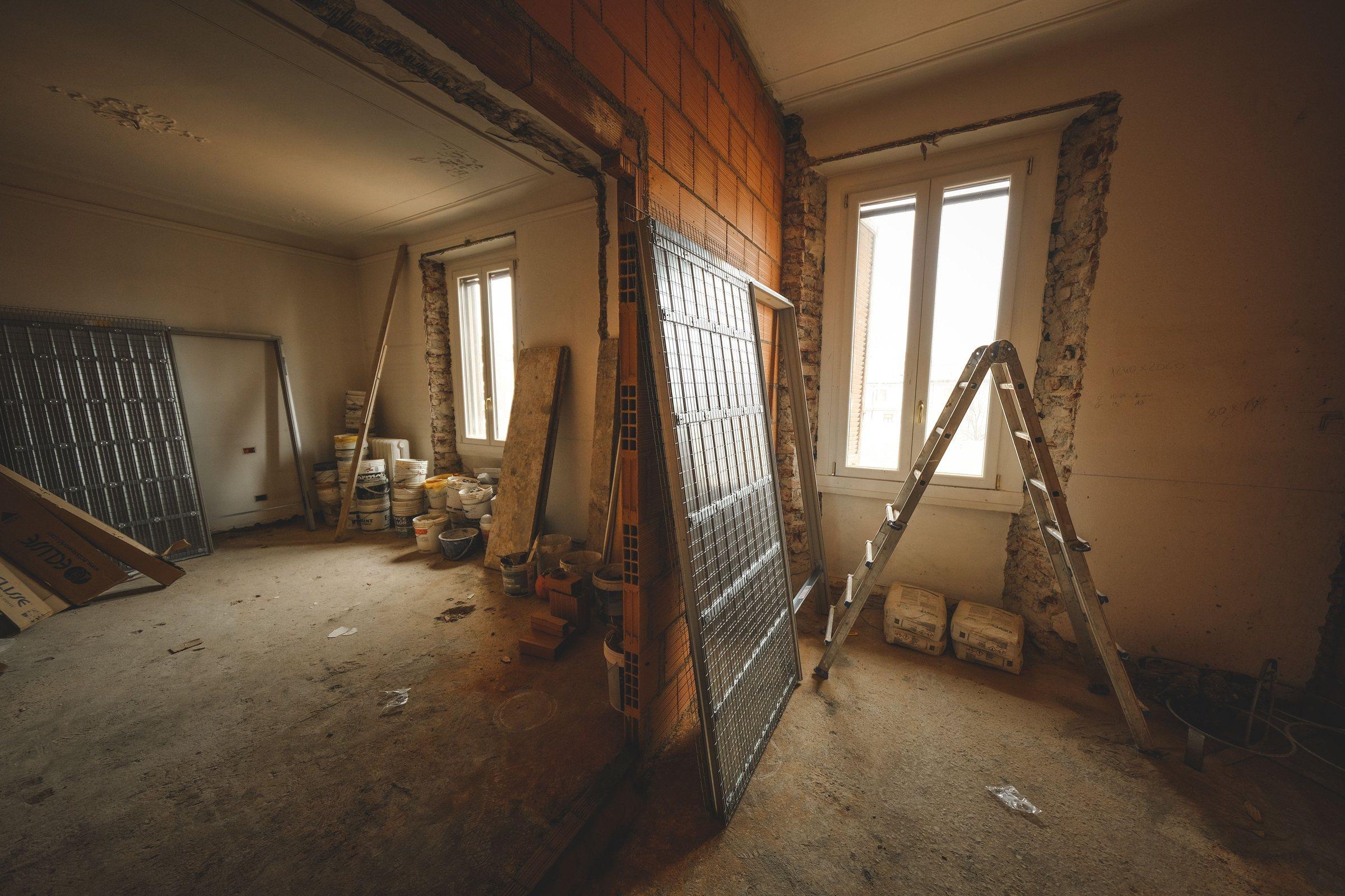 Kernsanierung im Ruhrgebiet – entkernte Wohnung im Rohbau mit Leiter und Baumaterial
