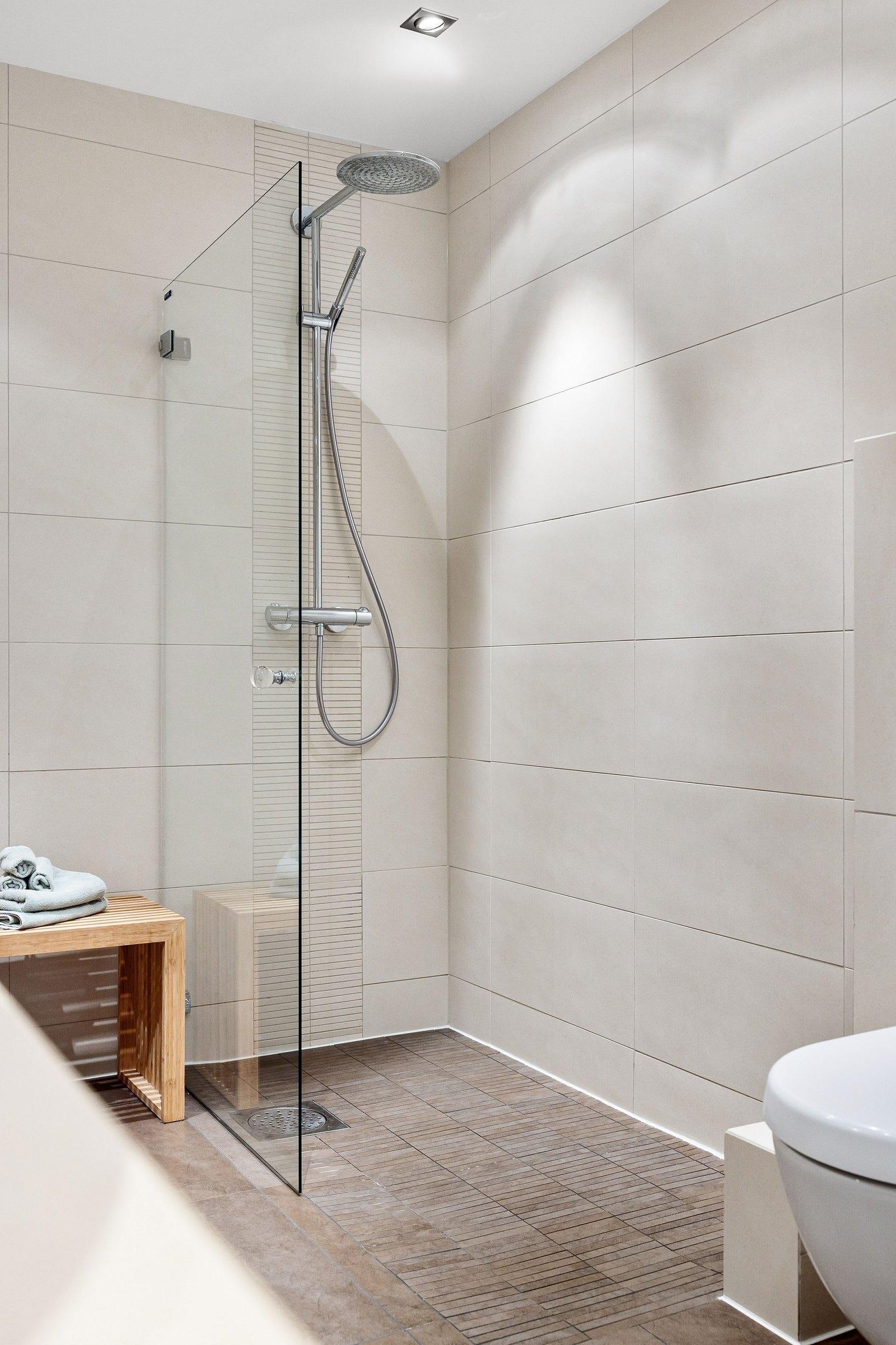 Bodengleiche Dusche mit Glaswand und Regendusche nach einer Badsanierung